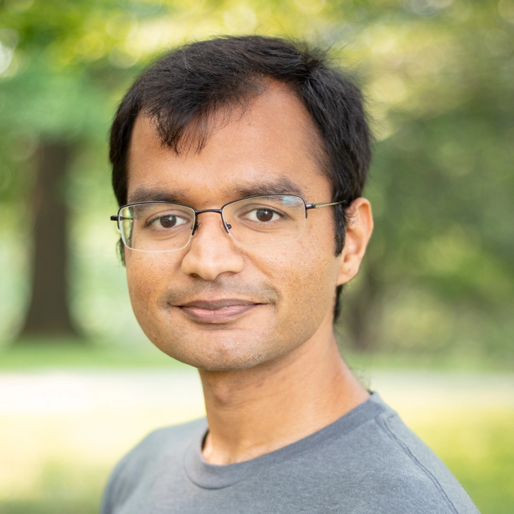 Portrait of Shubham Kanodia outdoors with a soft green background.